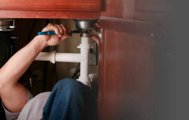 plumber working under the sink